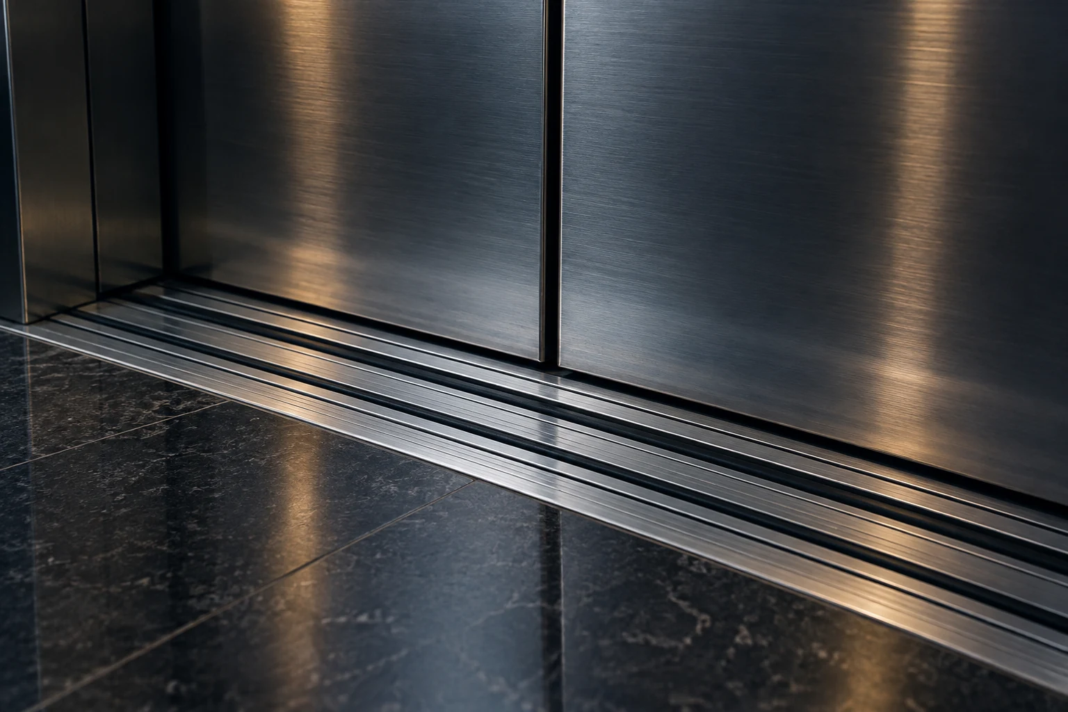 Precision grooves in a brushed-steel elevator door sill, viewed in close-up.