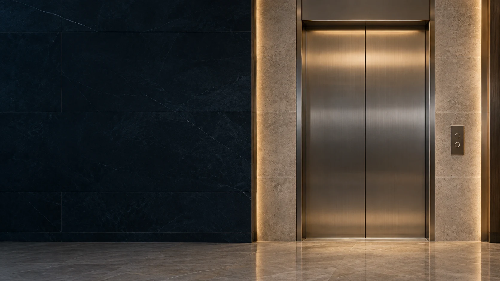 Closed bronze elevator doors framed by warm stone and a deep navy architectural wall